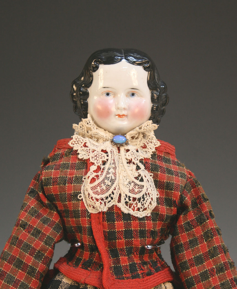 A late 19th Century porcelain head and shoulder doll, with black