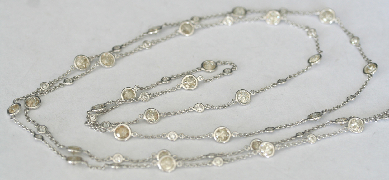 A diamond necklace, collet set with circular cut diamonds alternating ...