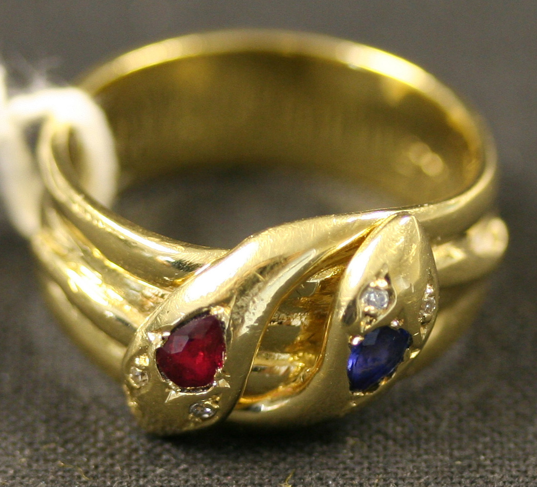 A gold, ruby, sapphire and diamond set ring designed as two conjoined ...