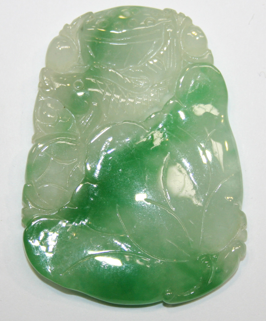 A Chinese jadeite pendant, probably early 20th Century, carved with a ...
