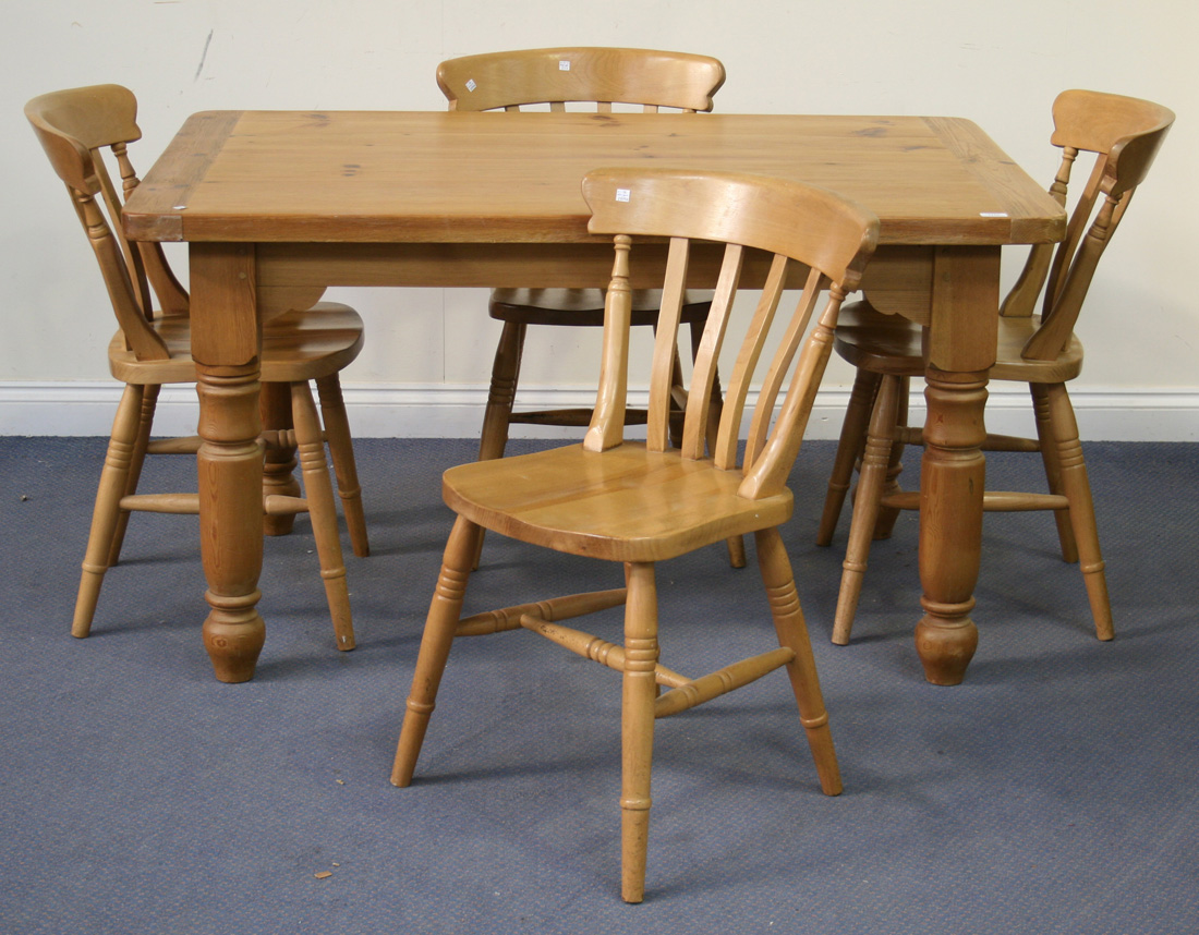 A modern pine kitchen table and four bar and spindle back chairs with ...
