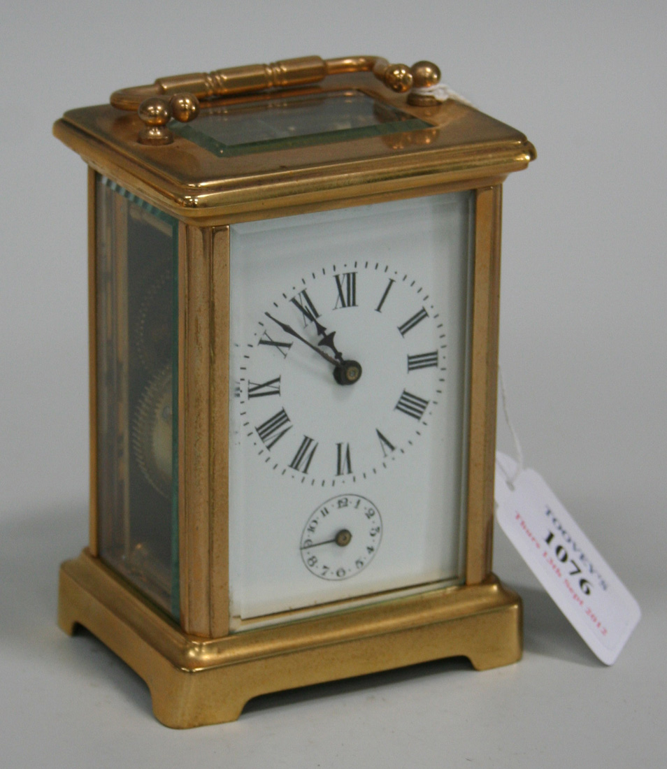 An early 20th Century brass cased carriage alarm clock, the enamel dial ...