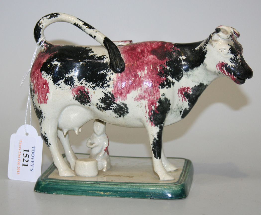A Staffordshire pottery cow creamer and milkmaid group, early 19th ...