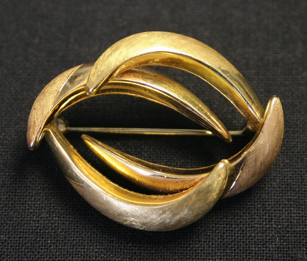 A two colour gold brooch in an entwined design with a textured finish ...