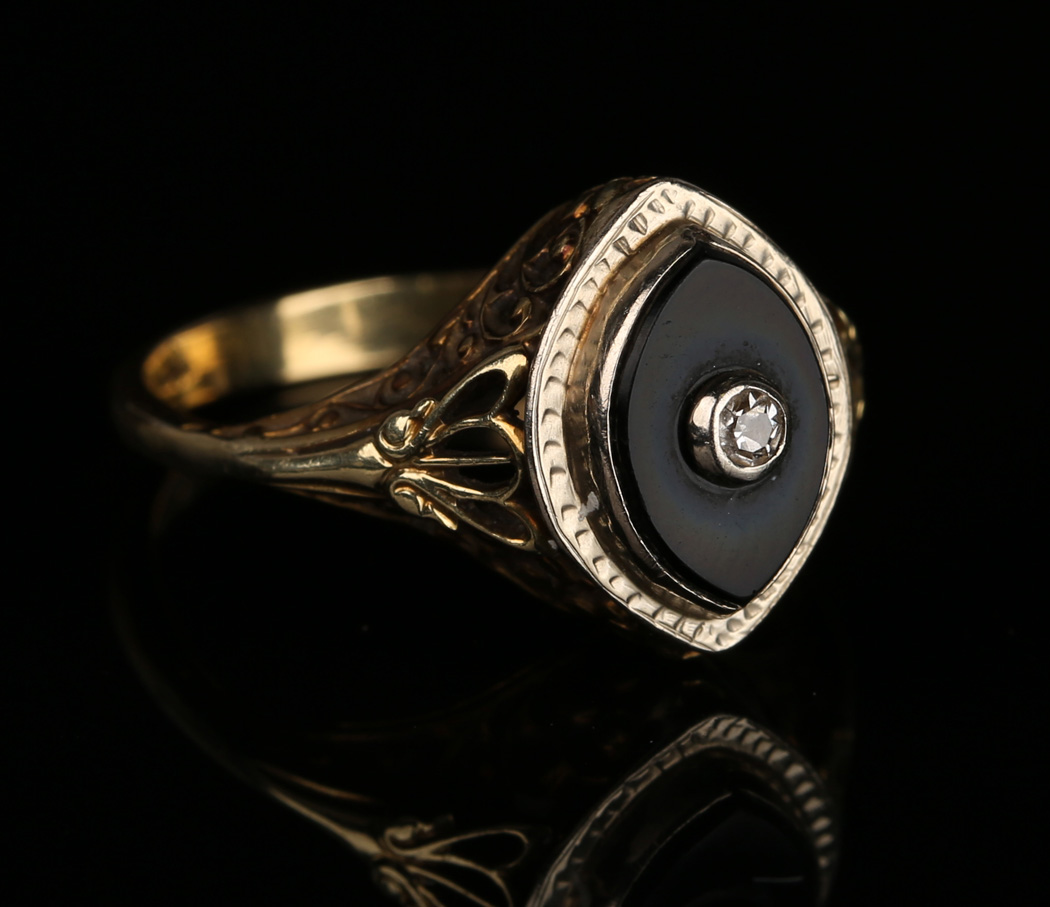 A Gold Diamond And Black Onyx Ring The Boat Shaped Black Onyx Mounted With A Cushion Shaped Diamon