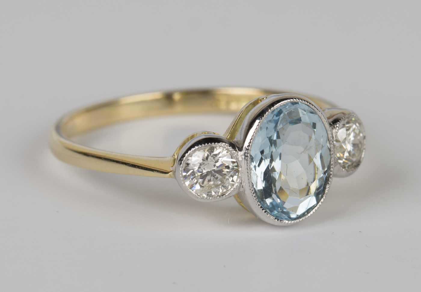 A gold, aquamarine and diamond three stone ring, collet set with the ...