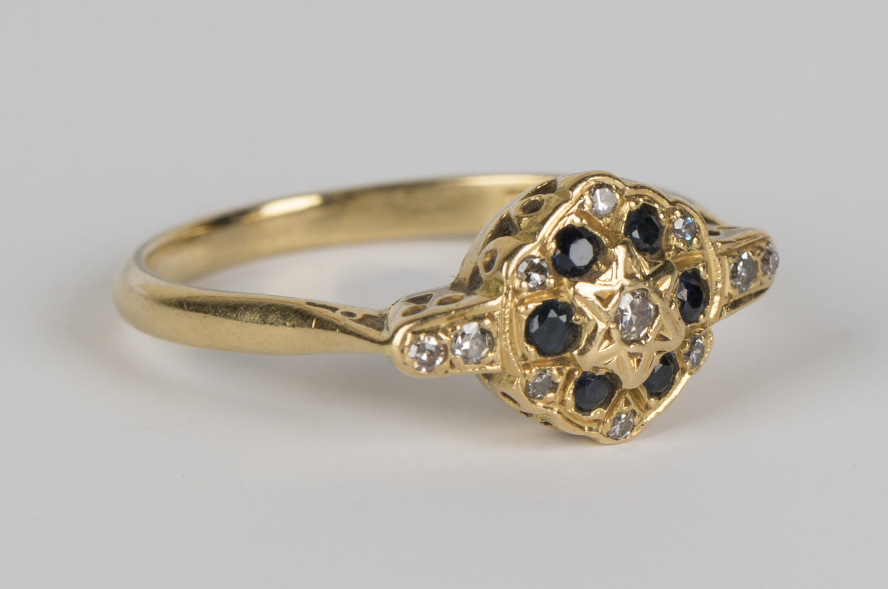 A gold, diamond and sapphire cluster ring, mounted with circular cut