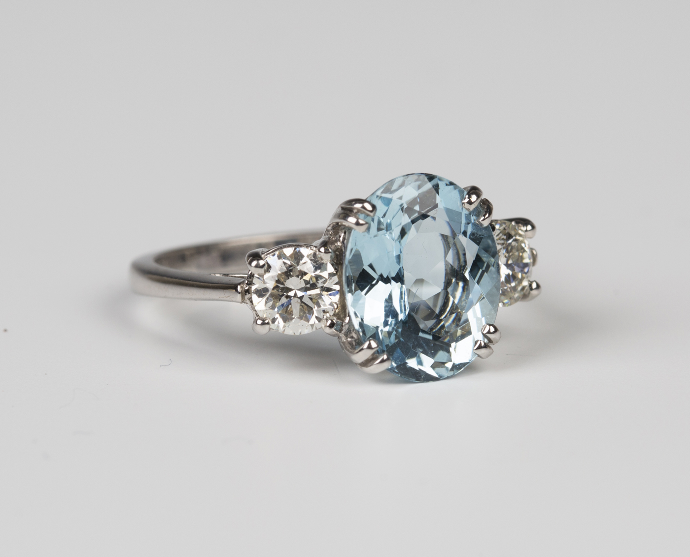 A white gold, aquamarine and diamond three stone ring, claw set with an ...