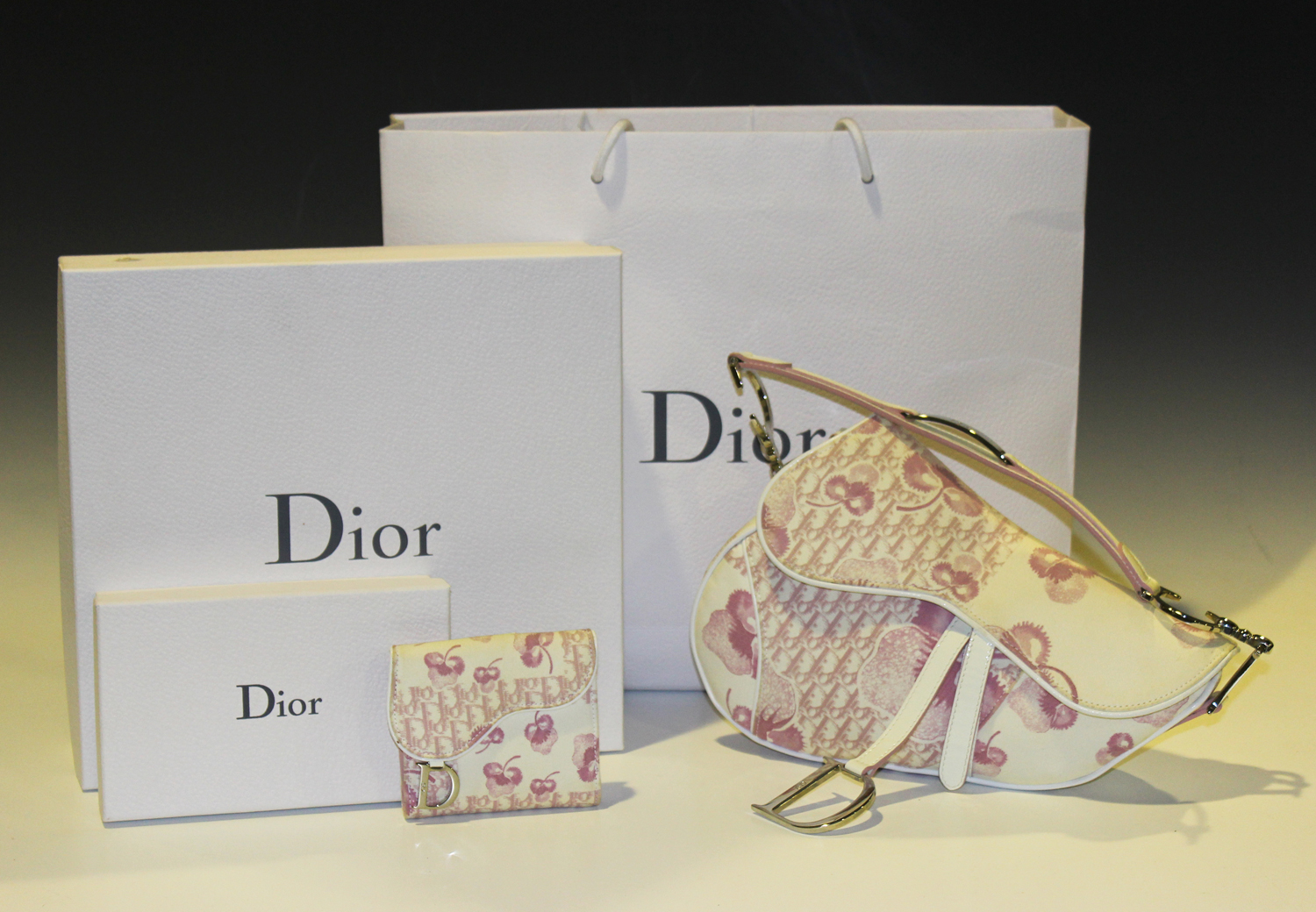 A Christian Dior pink floral canvas saddle shaped handbag, length