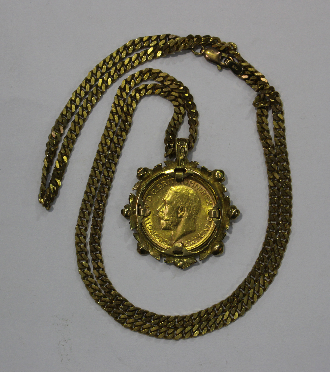 A George V sovereign 1911, in a 9ct gold pendant mount with cast floral ...