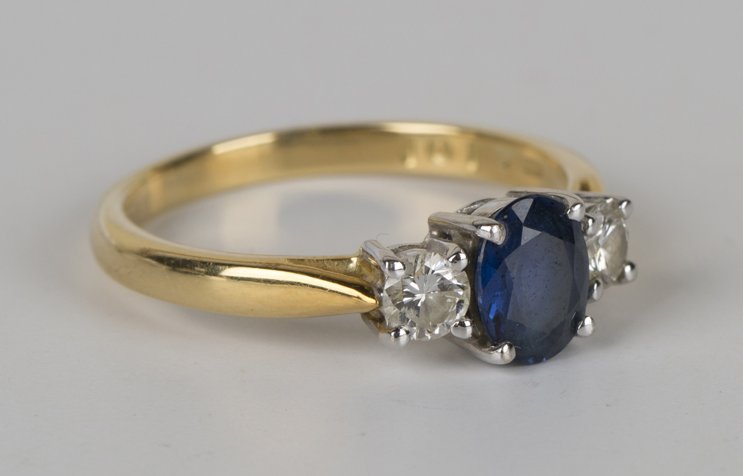 An 18ct gold, sapphire and diamond three stone ring, claw set with the ...