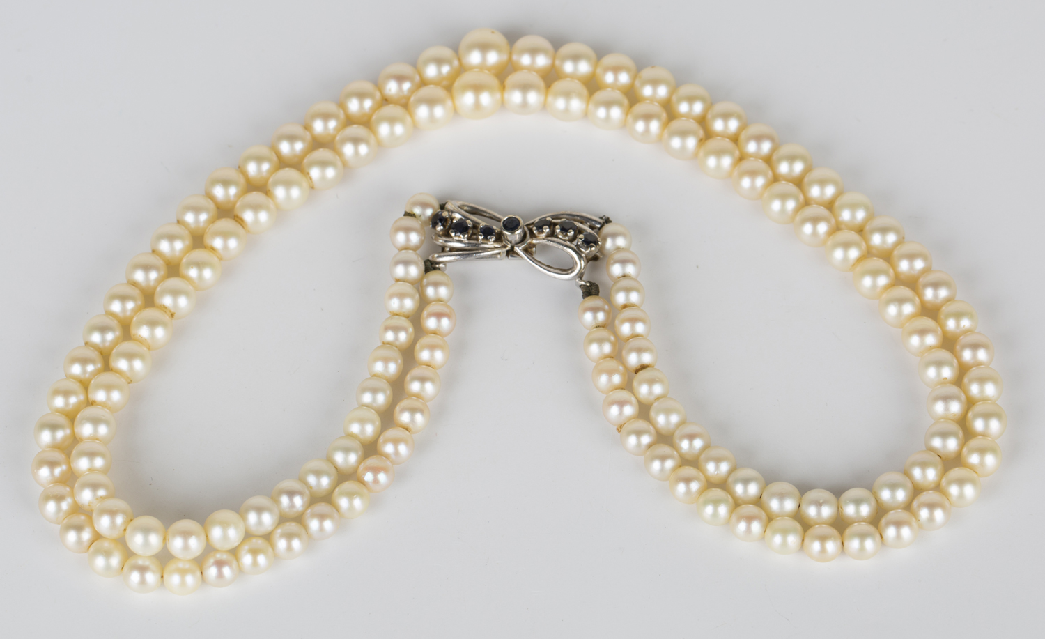 A three row necklace of graduated cultured pearls on a white gold and ...