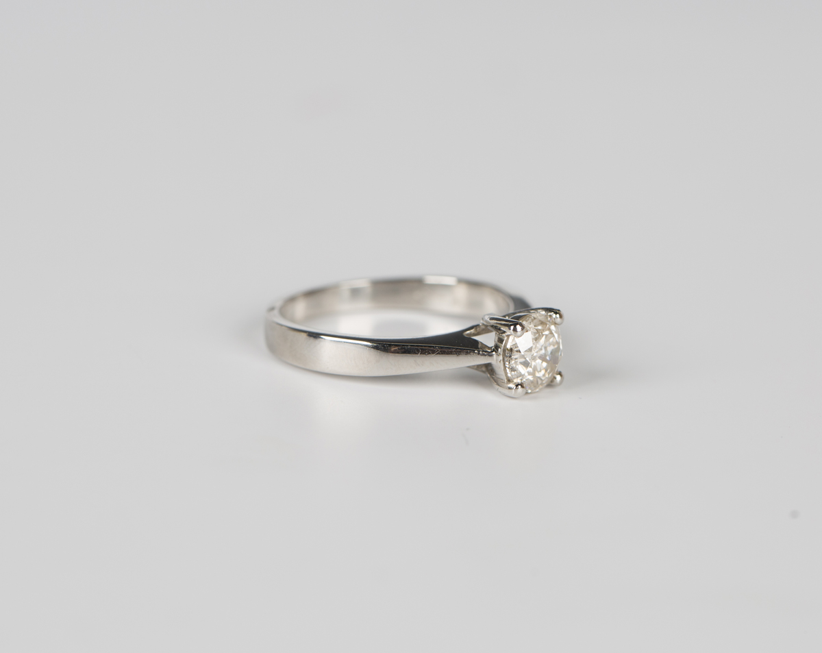 A platinum and diamond single stone ring, claw set with a circular cut ...