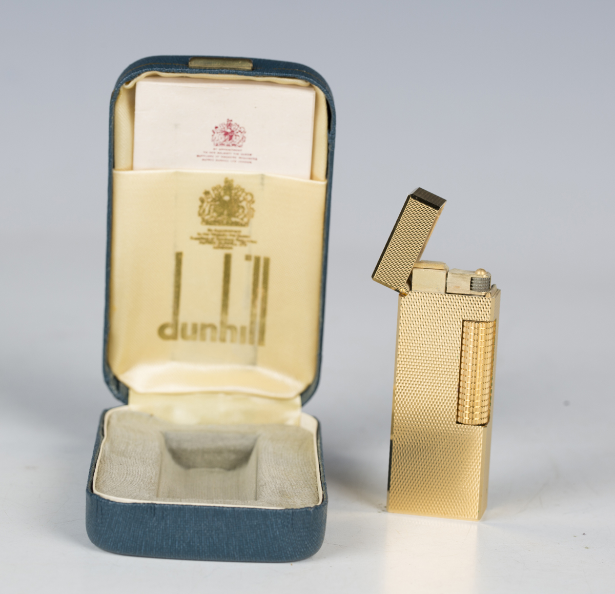 A Dunhill gold plated rectangular gas lighter, with engine turned ...
