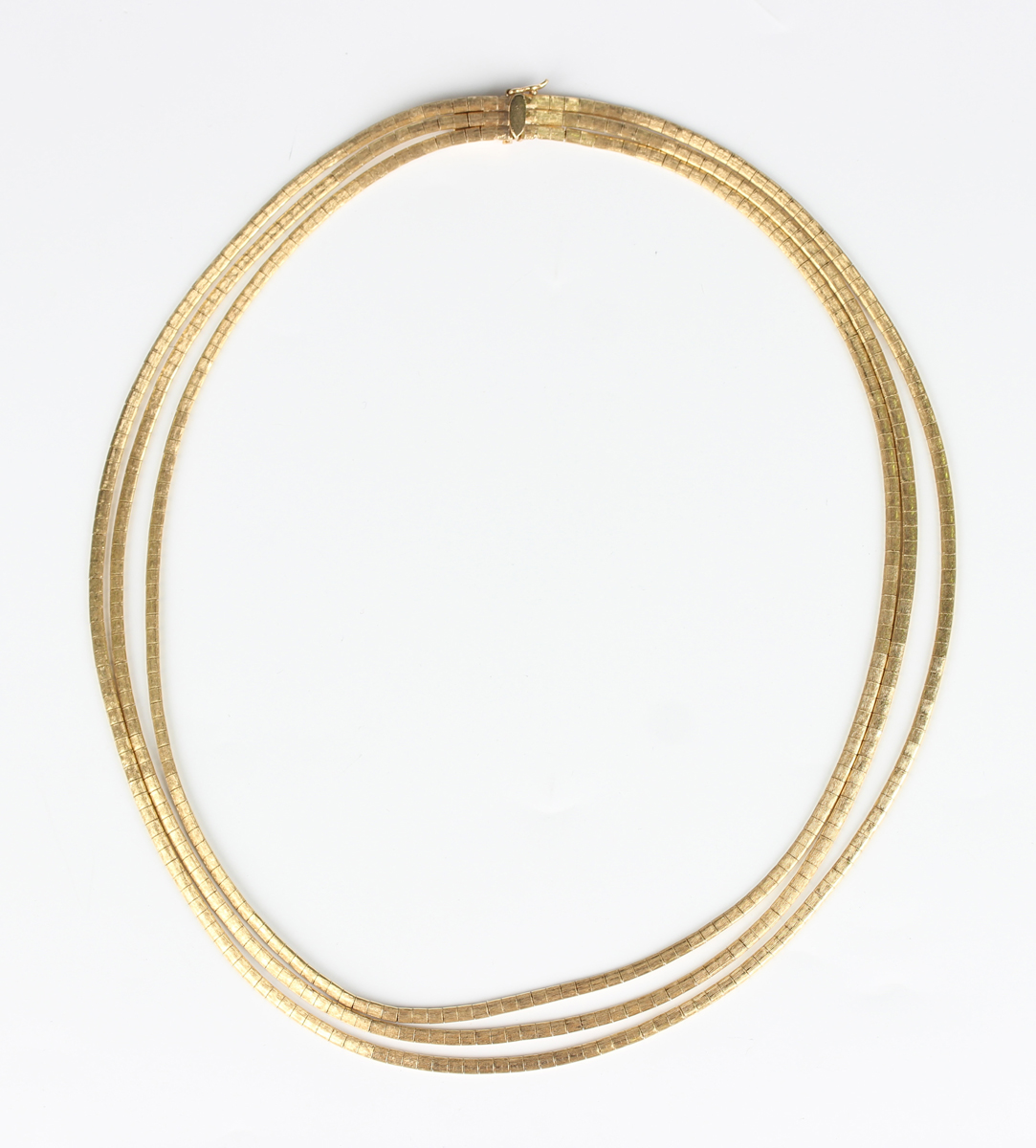 A three row gold necklace in a textured design, on a rectangular snap ...