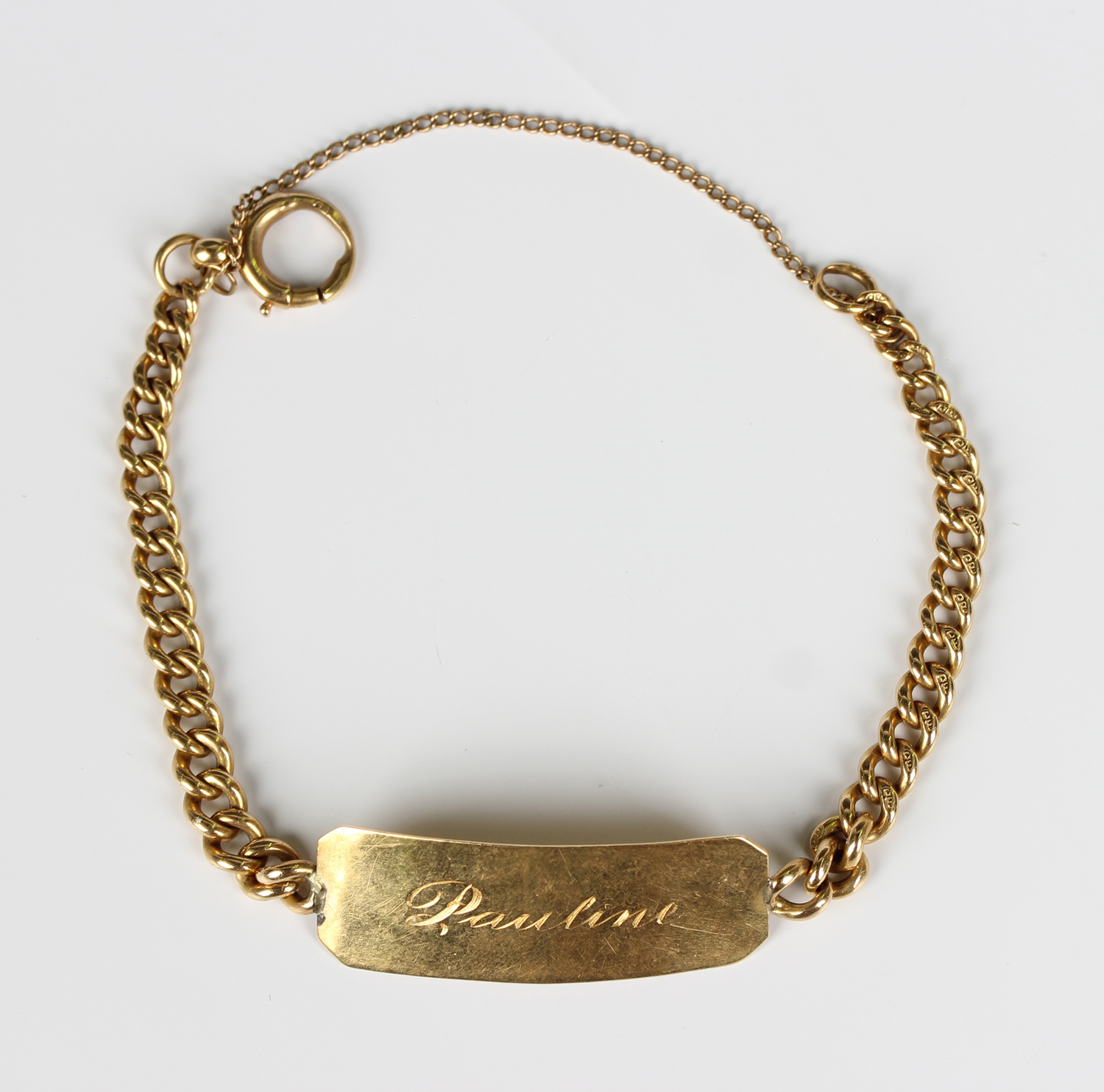 An 18ct gold curblink identity bracelet, engraved 'Pauline', with a ...