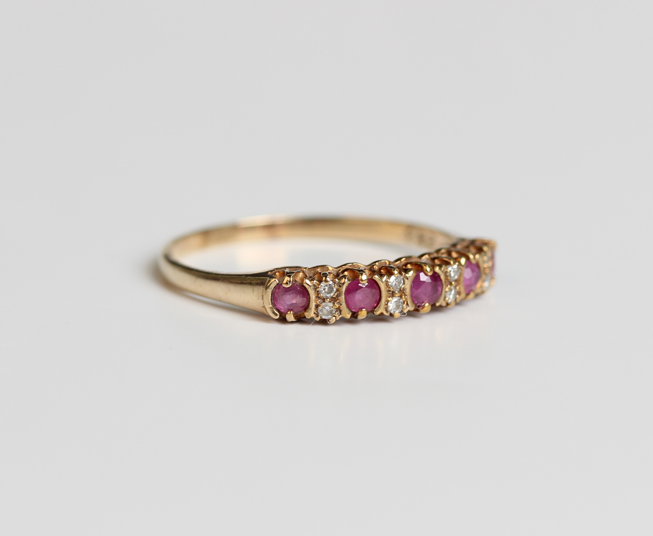 A 9ct gold ruby and diamond half hoop ring, mounted with five circular ...