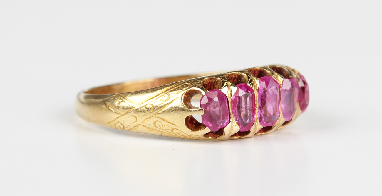 A gold and ruby five stone ring, mounted with a graduated row of oval ...