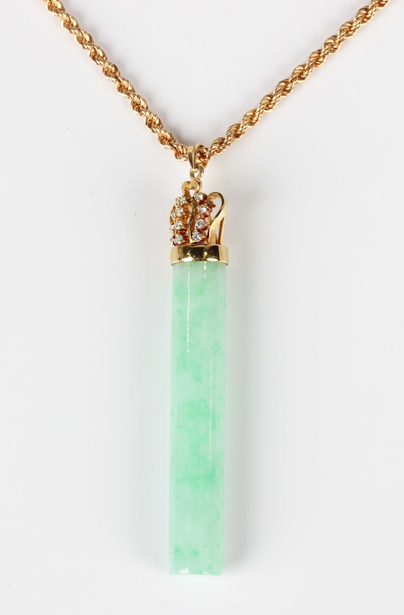 A gold, jade and diamond pendant, the cylindrical jade rod with a ...