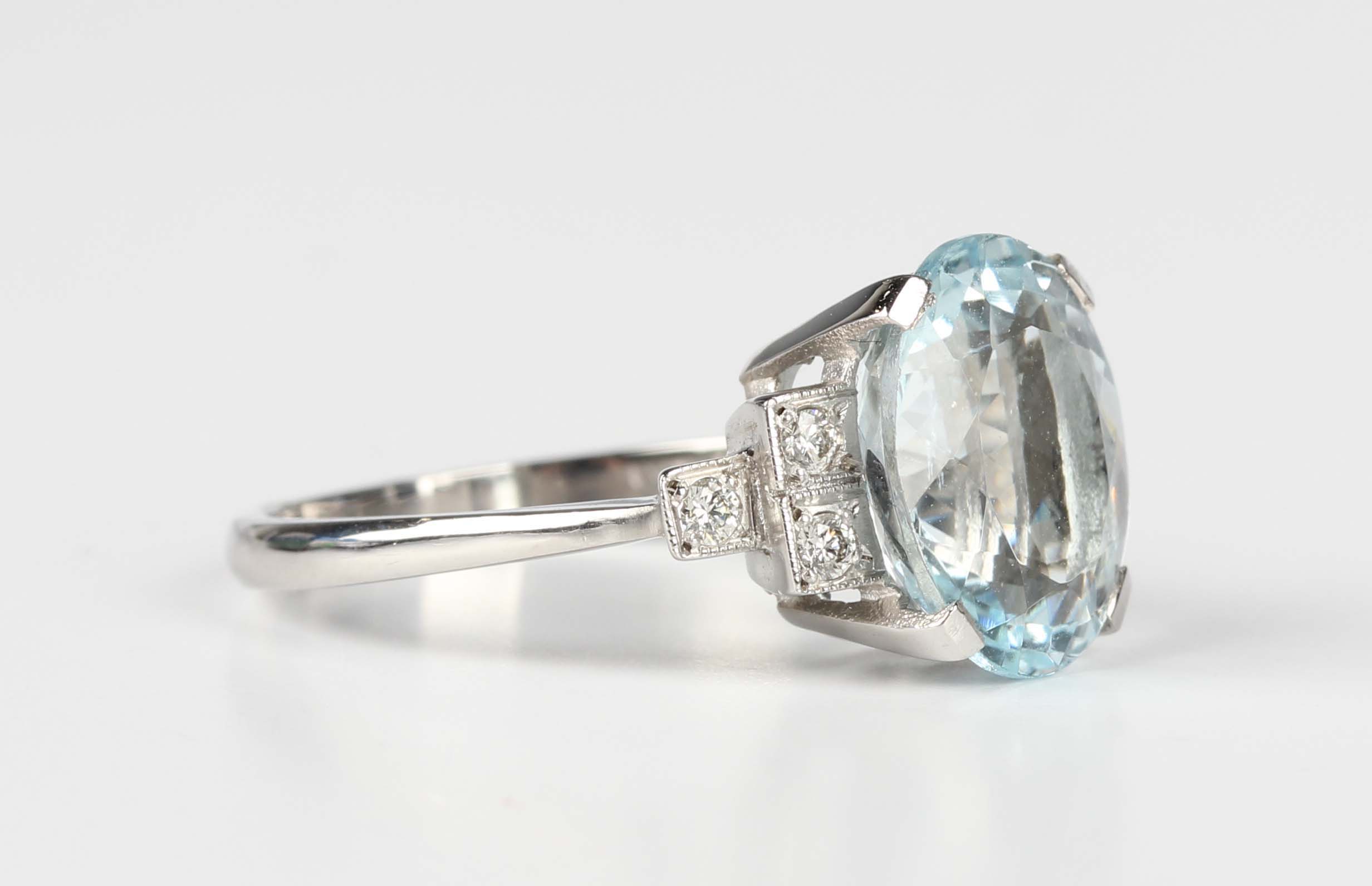 A platinum, aquamarine and diamond ring, claw set with the oval mixed ...