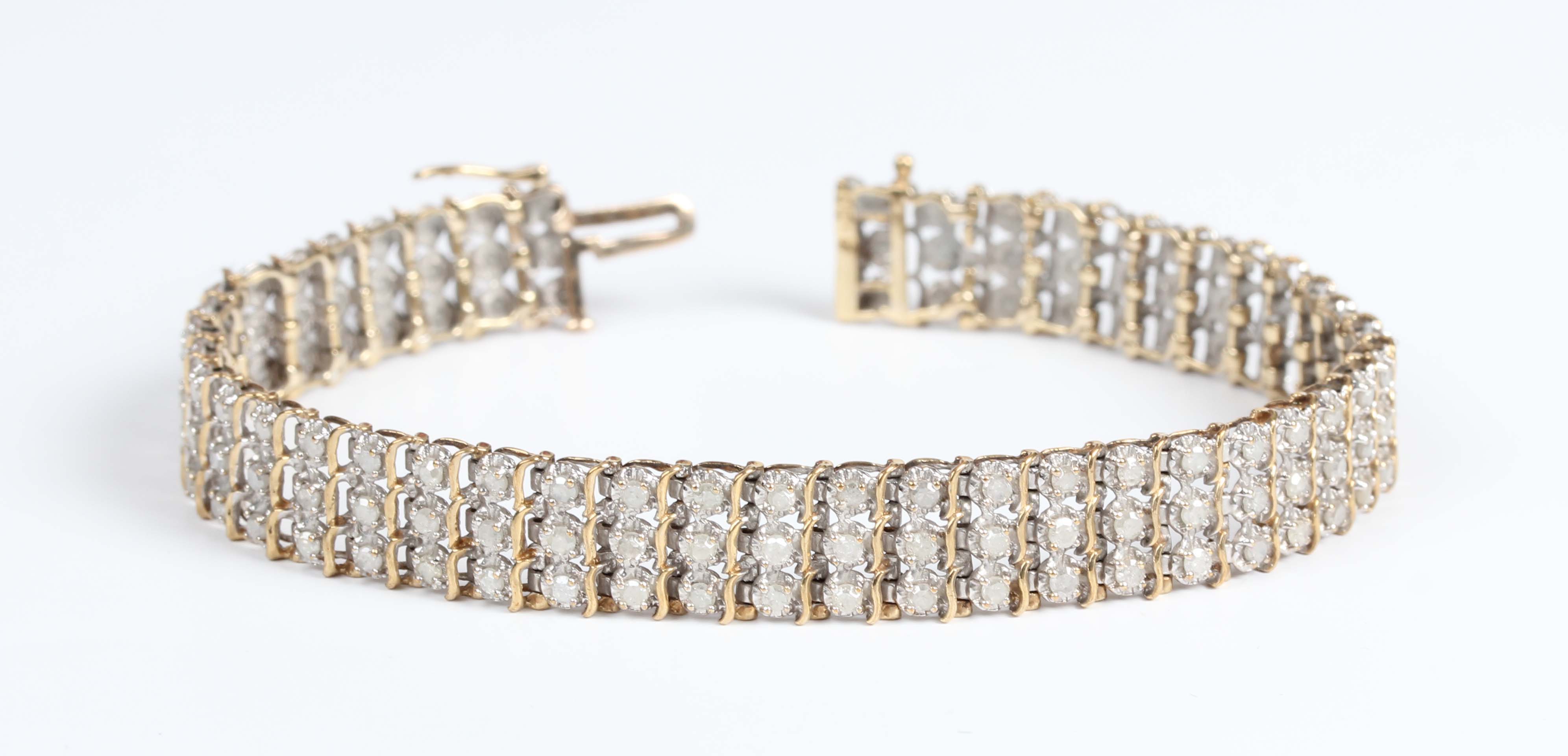 A 9ct gold and diamond bracelet in a three row design, mounted with ...